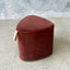 Brown ottoman with a handle on a concrete surface